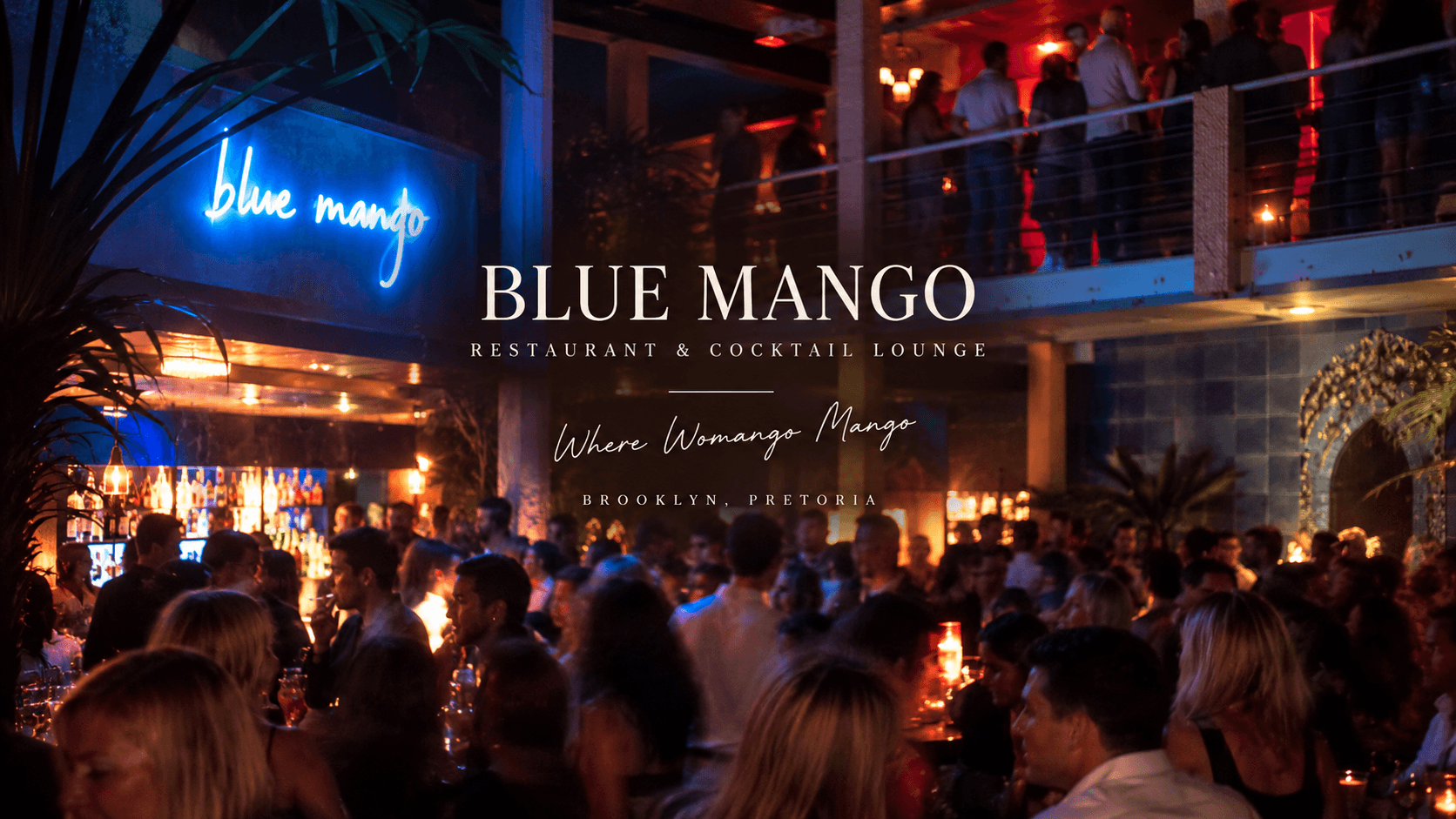 Blue Mango, restaurant and cocktail lounge, Brooklyn, Pretoria: the neon sign over a crowded bar, the balcony full above