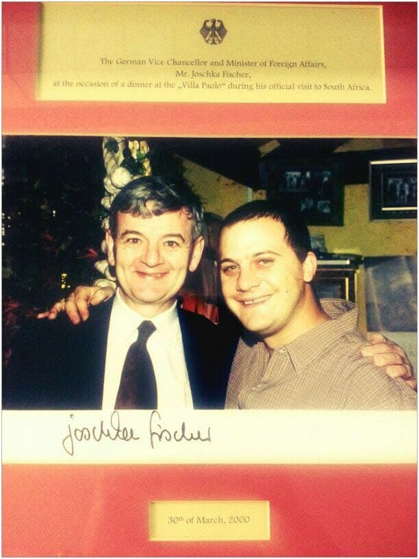 The framed photograph of Paul with German Vice Chancellor Joschka Fischer at Villa Paolo, with the printed plaque, his signature and the date, 30 March 2000